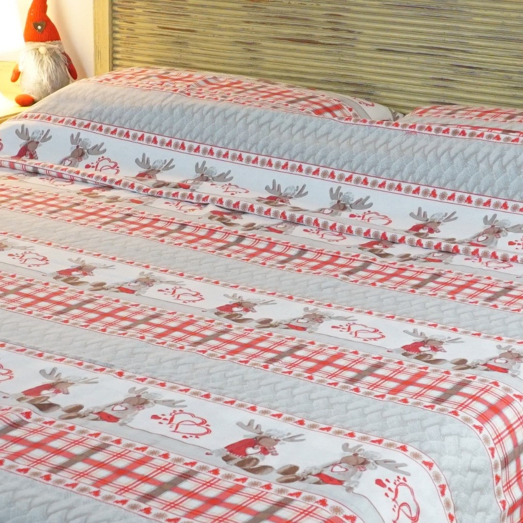 Camera da letto arredata con trapunta invernale double face con renne e cuoricini